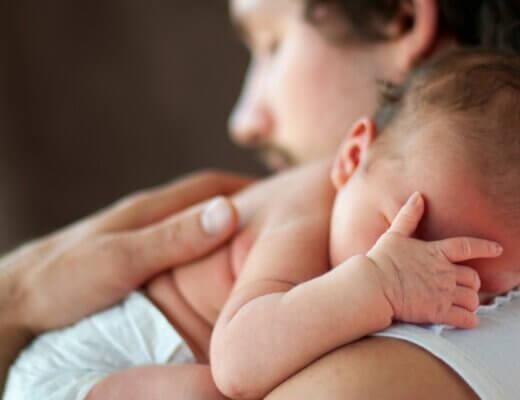 niemowlak oparty o ramię rodzica